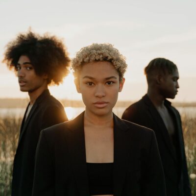 Curly Hair Woman With Men Standing Behind Her 