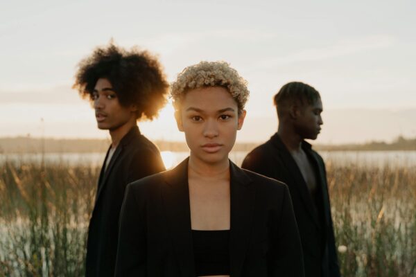 Curly Hair Woman With Men Standing Behind Her